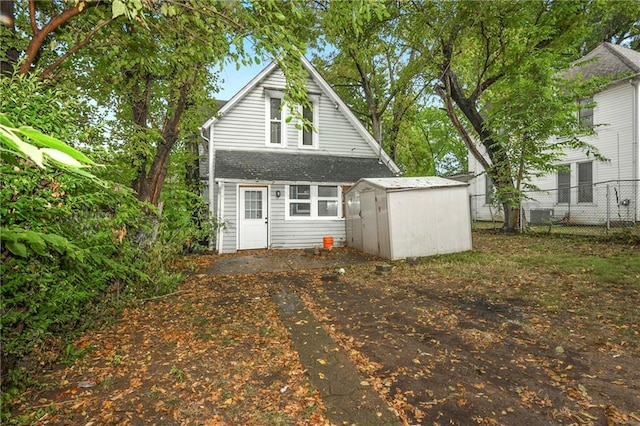 back of house featuring a storage unit