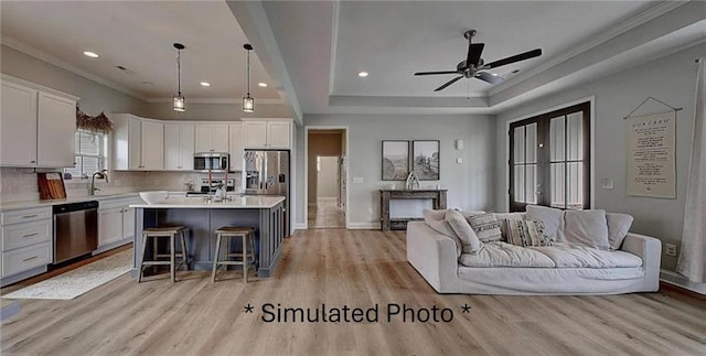 kitchen featuring stainless steel appliances, a center island, a kitchen bar, white cabinets, and light hardwood / wood-style floors