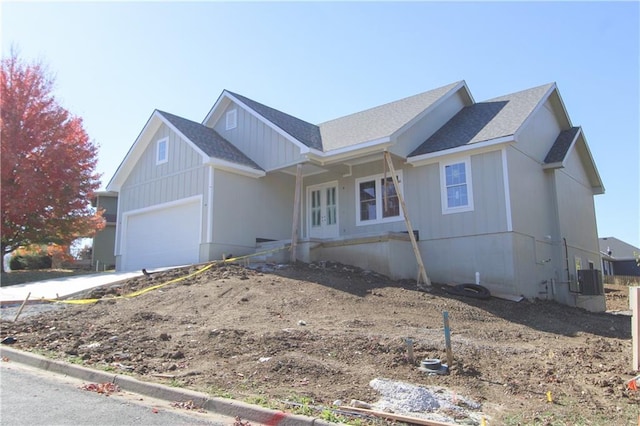 ranch-style home with central AC unit and a garage