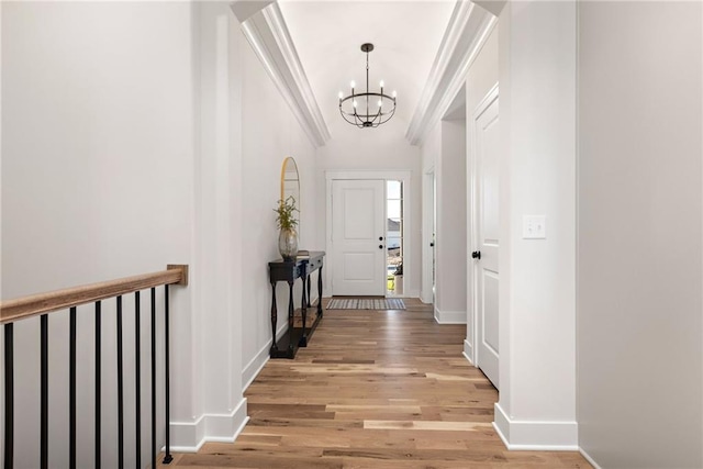 interior space featuring an inviting chandelier, light hardwood / wood-style floors, and ornamental molding