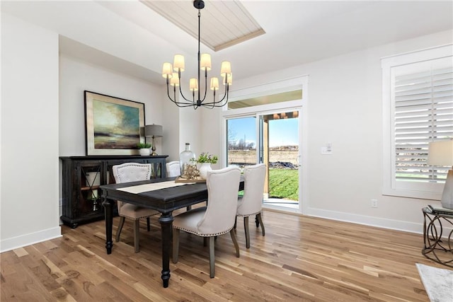 dining space featuring light wood-type flooring, a chandelier, and plenty of natural light