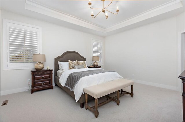 bedroom with a tray ceiling, an inviting chandelier, and light carpet