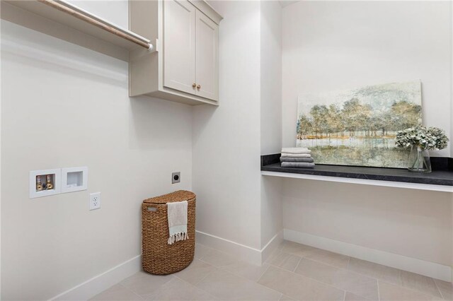 clothes washing area with hookup for a washing machine, light tile patterned flooring, hookup for an electric dryer, and cabinets