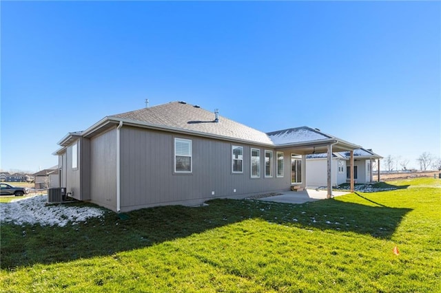 rear view of house with cooling unit, a lawn, and a patio