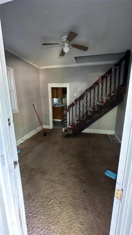 interior space featuring dark carpet and ceiling fan