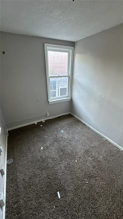 empty room with a textured ceiling and carpet