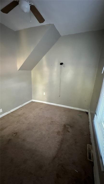 additional living space with ceiling fan, lofted ceiling, and dark carpet