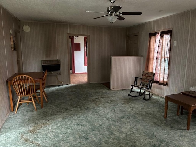 sitting room with a textured ceiling, carpet, ceiling fan, and heating unit