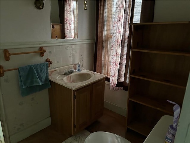 bathroom with vanity, backsplash, and toilet