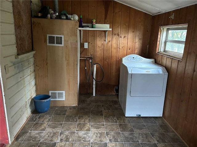 clothes washing area featuring washer / clothes dryer and wooden walls