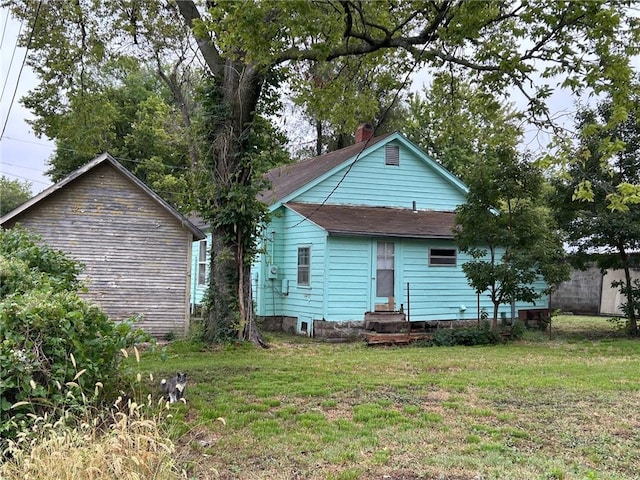 rear view of property featuring a lawn