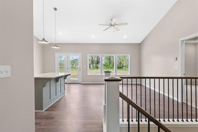 hall with dark wood-style floors and an upstairs landing