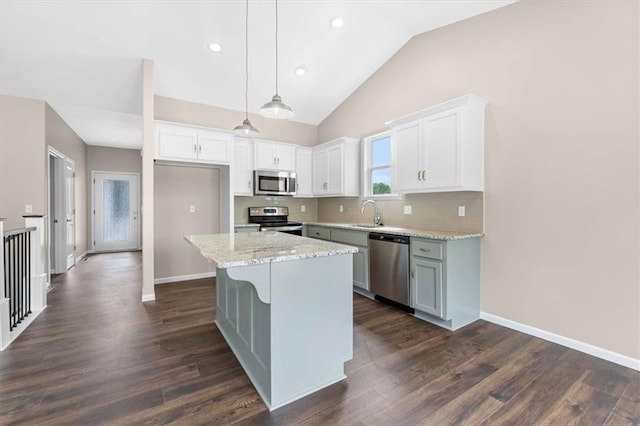 kitchen with tasteful backsplash, stainless steel appliances, white cabinetry, and dark wood-type flooring