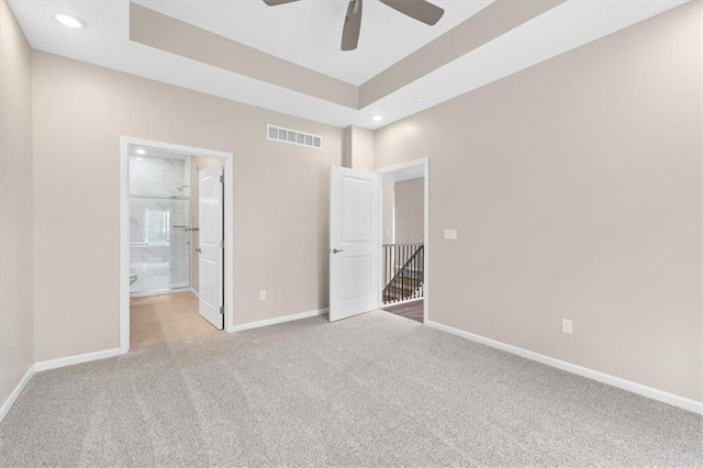 unfurnished bedroom featuring ensuite bath, visible vents, baseboards, carpet flooring, and recessed lighting