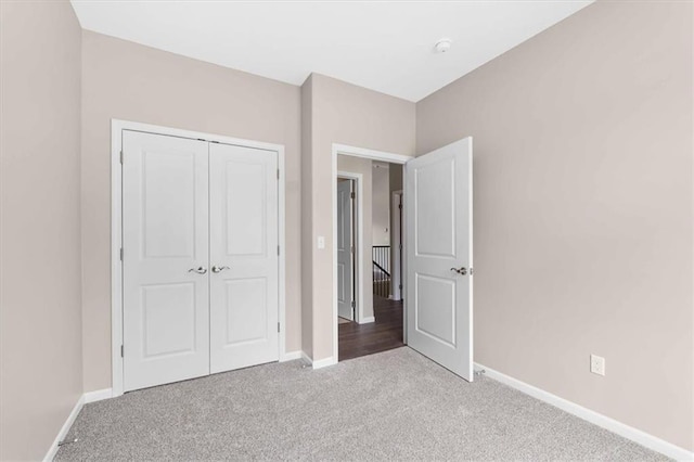 unfurnished bedroom with carpet flooring, baseboards, and a closet
