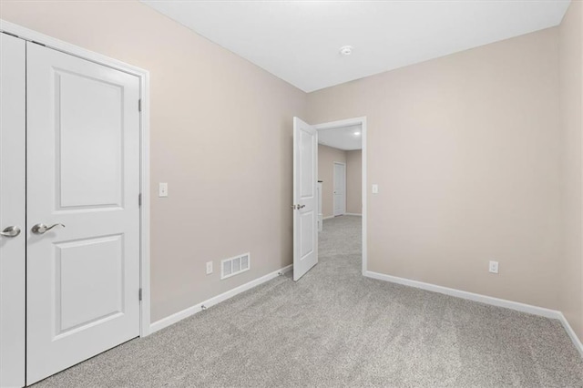 unfurnished bedroom featuring visible vents, baseboards, and light colored carpet