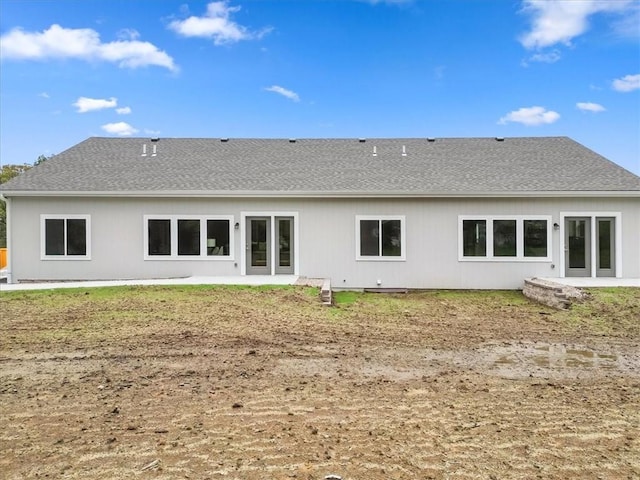 rear view of property featuring a shingled roof and a patio area