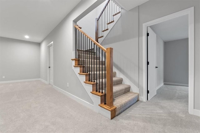 staircase featuring carpet