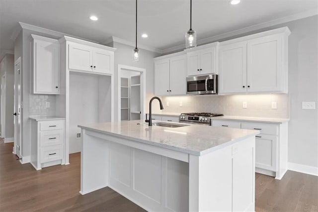 kitchen with a center island with sink, stainless steel appliances, sink, white cabinets, and pendant lighting