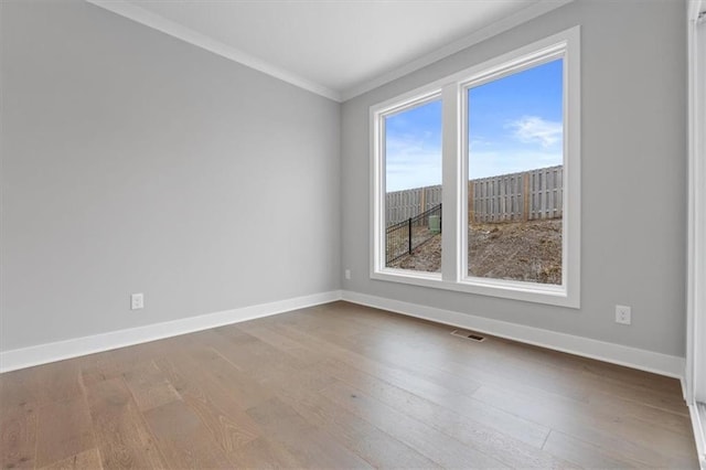 empty room featuring crown molding and hardwood / wood-style floors