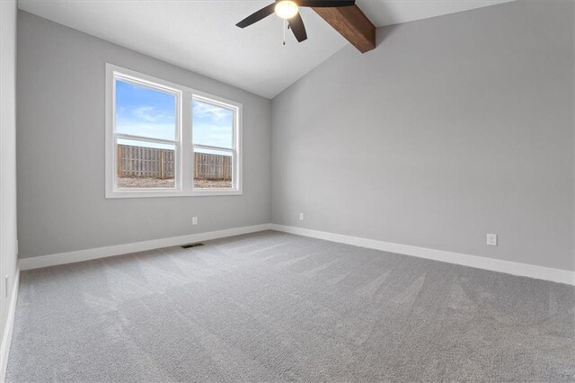 carpeted empty room featuring ceiling fan and lofted ceiling with beams