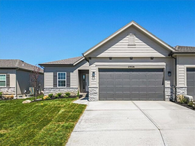 view of front of home with concrete driveway, an attached garage, stone siding, and a front lawn