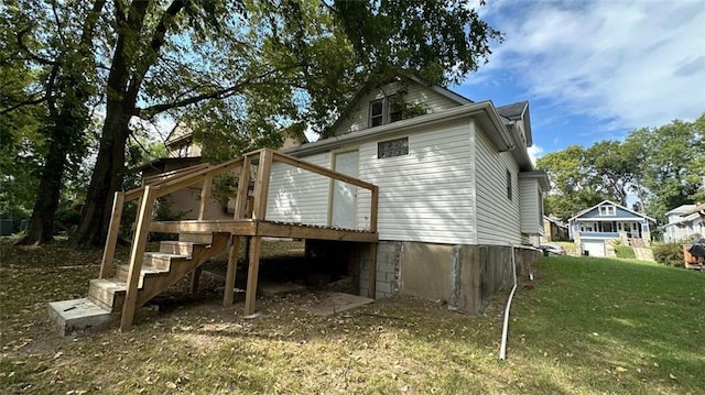 back of house with a lawn and a deck