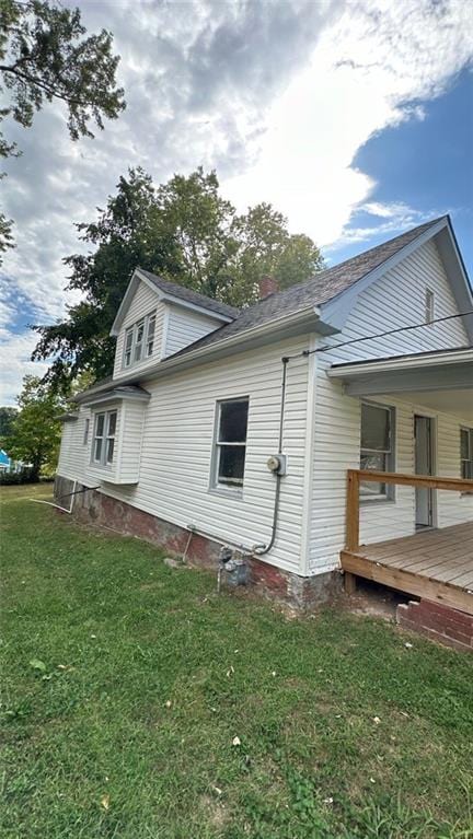 view of side of property with a wooden deck and a yard