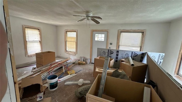 miscellaneous room featuring ceiling fan, a healthy amount of sunlight, and a textured ceiling