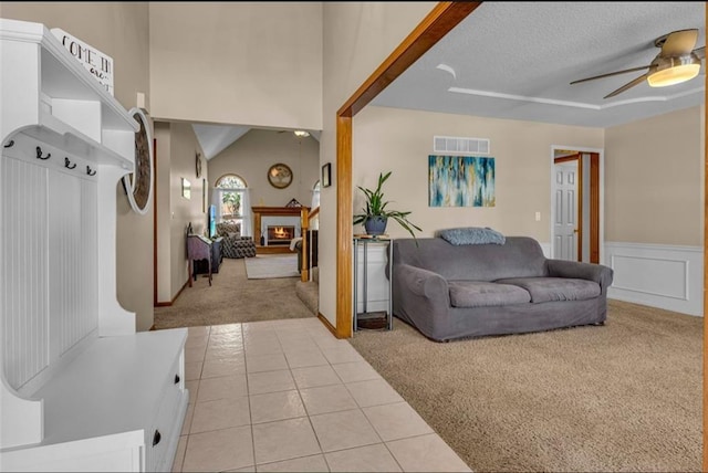 carpeted living room with ceiling fan, lofted ceiling, and a textured ceiling