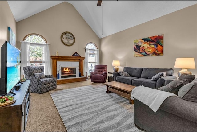 living room featuring high vaulted ceiling, light colored carpet, a tile fireplace, and a wealth of natural light