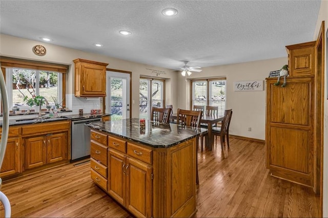 kitchen with a wealth of natural light, sink, a center island, and light wood-type flooring