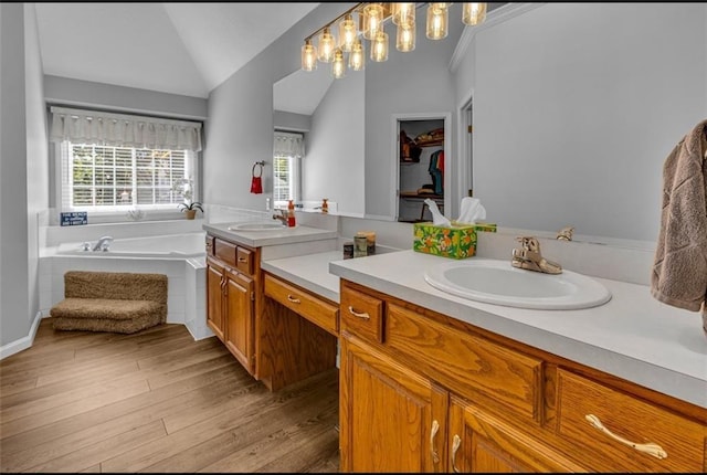 bathroom featuring hardwood / wood-style floors, vanity, a relaxing tiled tub, and lofted ceiling