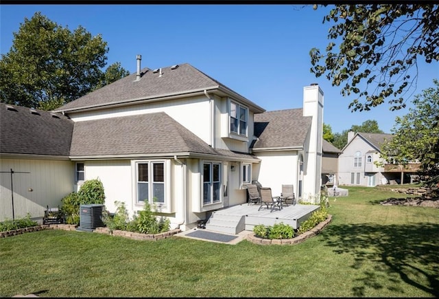 rear view of property featuring a lawn, a wooden deck, and central AC unit