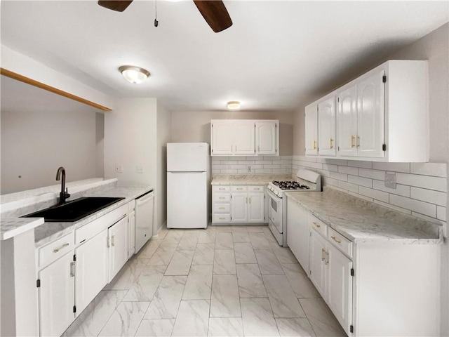 kitchen with ceiling fan, sink, tasteful backsplash, white appliances, and white cabinetry