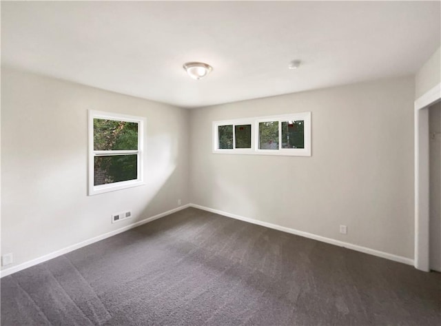 unfurnished room with dark carpet