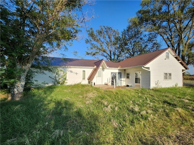 rear view of house featuring a yard