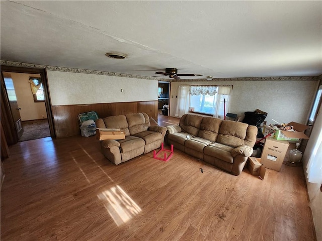 living room with wooden walls, ceiling fan, and hardwood / wood-style flooring