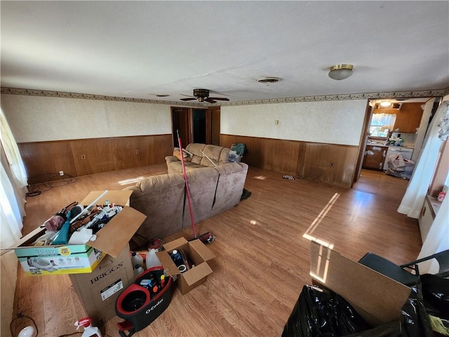 living room featuring wood walls, ceiling fan, and hardwood / wood-style floors