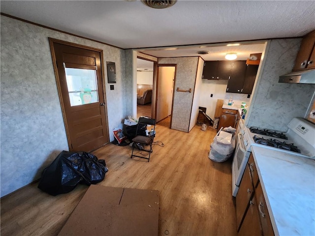 kitchen featuring a textured ceiling, light hardwood / wood-style floors, and white gas stove