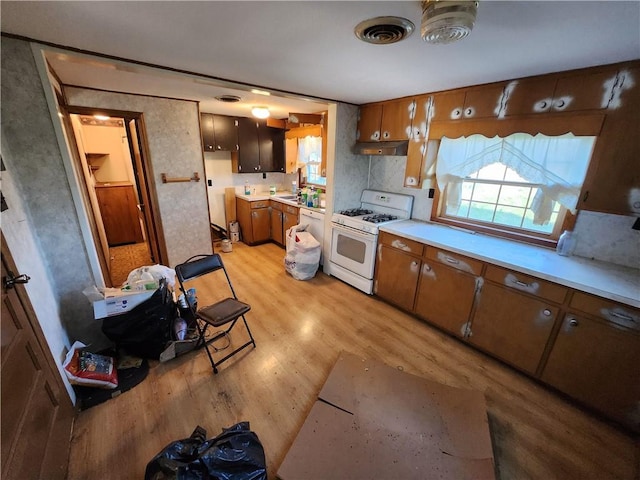 kitchen with light hardwood / wood-style flooring and gas range gas stove