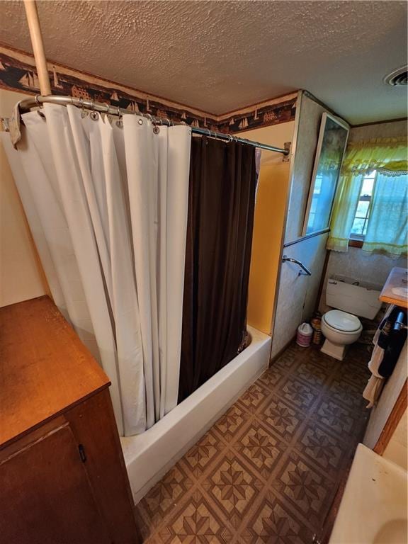 full bathroom with shower / tub combo with curtain, a textured ceiling, and toilet