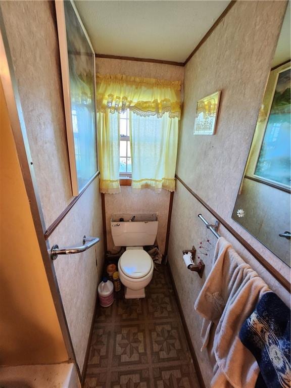 bathroom featuring ornamental molding and toilet