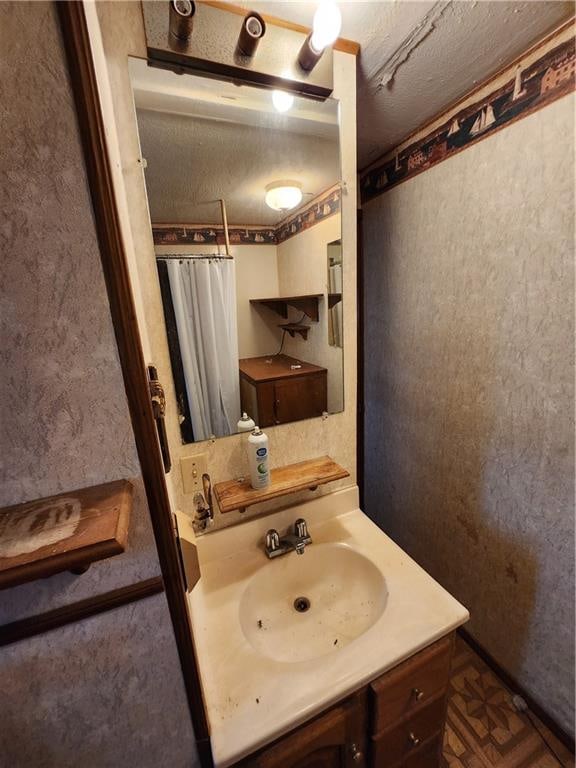 bathroom featuring a textured ceiling and vanity