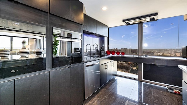 kitchen featuring dark stone counters, recessed lighting, a sink, stainless steel dishwasher, and modern cabinets