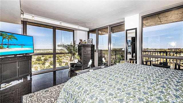 bedroom featuring track lighting, access to exterior, and floor to ceiling windows