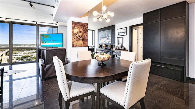 dining room with floor to ceiling windows and a notable chandelier