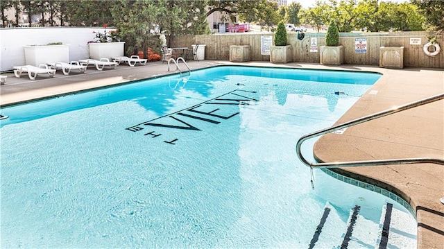 community pool featuring a patio and fence