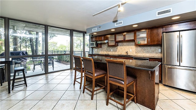 kitchen featuring light tile patterned floors, visible vents, a sink, stainless steel appliances, and backsplash