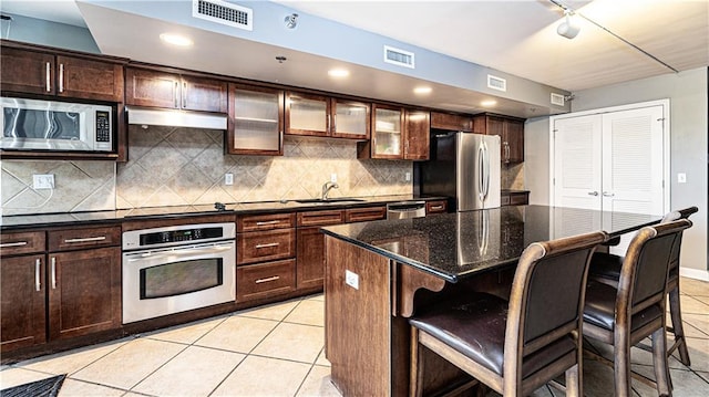 kitchen featuring a sink, stainless steel appliances, visible vents, and light tile patterned floors